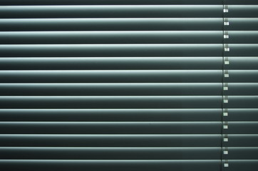 Obraz premium Closed venetian blinds or shutters background. Daylight coming through closed metallic blinds.Nighttime privacy.