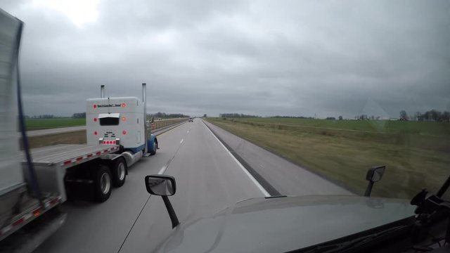 A Flatbed Semi Truck Passes the viewer on a rural highway in Tennessee, USA.