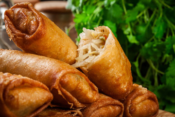 Spring rolls with chicken and vegetables on chopping board