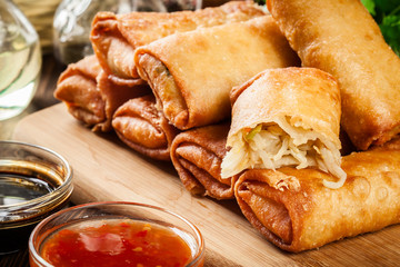 Spring rolls with chicken and vegetables on chopping board