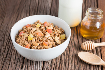 Granola with dried fruits and nuts in white bowl.
