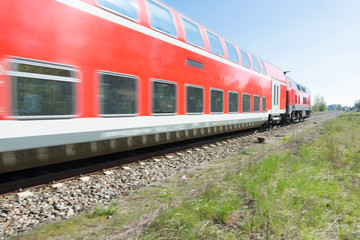 Fototapeta premium Roter Triebwagen zieht Eisenbahnwaggon
