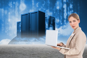 Businesswoman holding a laptop near to storage units