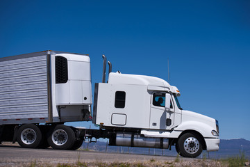 Naklejka premium Power Semi truck rig and reefer trailer side view