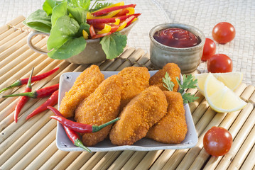 Spicy Breaded chicken fillets with red chilly lemon and cherry tomatoes with ketchup and bell pepper salads