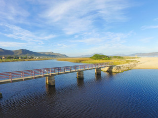Bridge over the Lagoon by the Ocean with Blue Skies