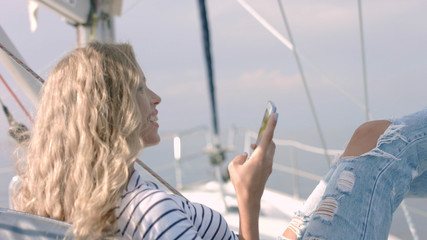 Young woman taking photo of beautiful sea lagoon on smartphone