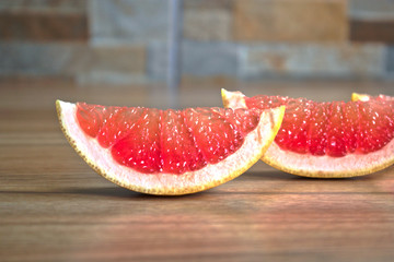 Closeup of grapefruit wedges on a wooden table