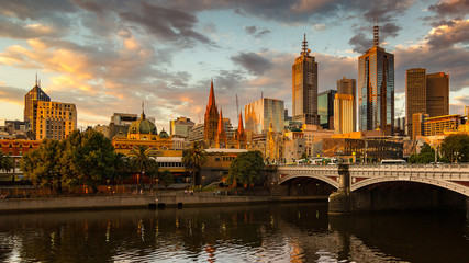 Naklejka premium Melbourne City, Yarra River, Princes Bridge with Reflection Cityscape Skyline background under dramatic Golden Sky Sunset, Australia