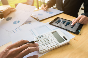 Two business colleagues discussing about data reseach of stock market in modern office