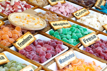 Colorful candied fruits assortment with a signs saying: mojito, Coconut, strawberry, tangerine and raspberry.