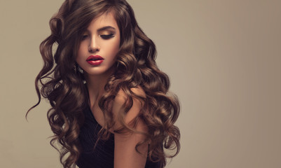 Brunette  girl with long  and   shiny wavy hair .  Beautiful  model with curly hairstyle . - 156188406