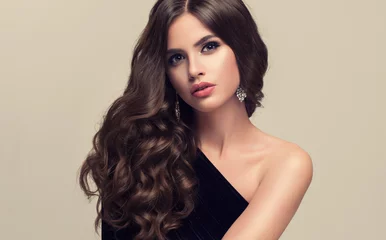 Cercles muraux Salon de coiffure Brunette  girl with long  and   shiny wavy hair .  Beautiful  model with curly hairstyle .