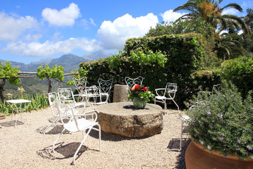 Mediterane Gartenterasse mit Stühlen und Tisch