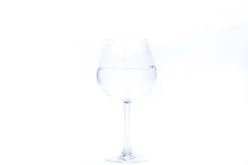 Crystal wineglass with water stands on white background