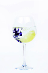 Yellow and violet paints fall in a wineglass with water
