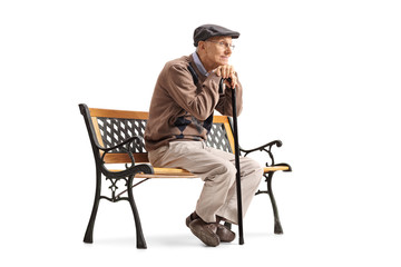 Pensive senior with a walking cane sitting on a bench