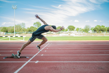 Young athlete running from crouch start on race track