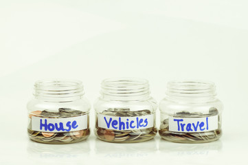 coins on bottle of money for house,car and travel