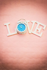 Fondo con la palabra "LOVE" en la que la letra O es sustituida por un reloj retro 