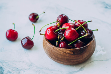 Fresh Ripe cherries in wooden bowl on table background. Summer berries. Healthy food concept. Copy space, top view