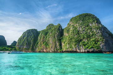 Fototapeta premium Tropical landscape with rock islands, lonely boat and crystal clear at Phi Phi island