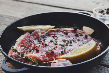 Raw beef steak closeup background with spices and herbs.