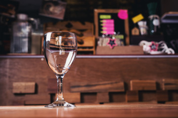 A glass of water is placed on a table in a coffee shop.