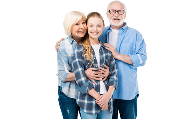 grandfather, grandmother and granddaughter huging together isolated on white