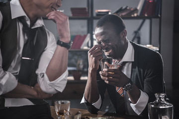 cheerful colleagues drinking alcohol while spending time together after work