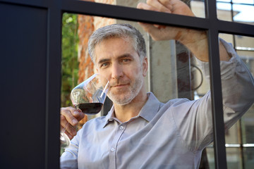 Przystojny mężczyzna w średnim wieku pije wino. - obrazy, fototapety, plakaty