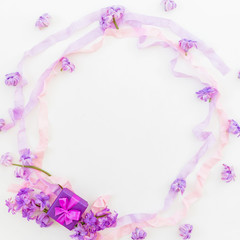 Purple round frame of pink flowers and tapes on white background. Flat lay, top view.
Ring box