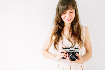 Fototapeta premium Young woman holding in hands old vintage camera. Girl photographer