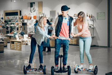 young man and woman riding on the Hoverboard in the moll. content technologies. a new movement....