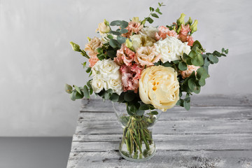 Bridal vintage bouquet. The bride's . Beautiful of mixed flowers and greenery, decorated with silk ribbon, lies on vintage wooden table. vintage style