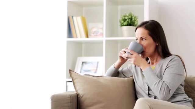 happy woman drinking tea or coffee at home