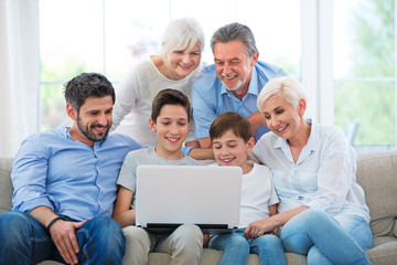Family using laptop on a sofa
