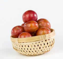 fruit Plum in a bamboo basket isolated on white background
