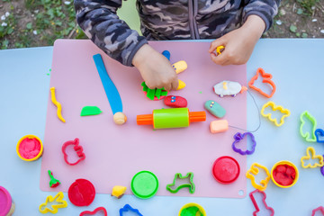 cute little boy playing with plasticine