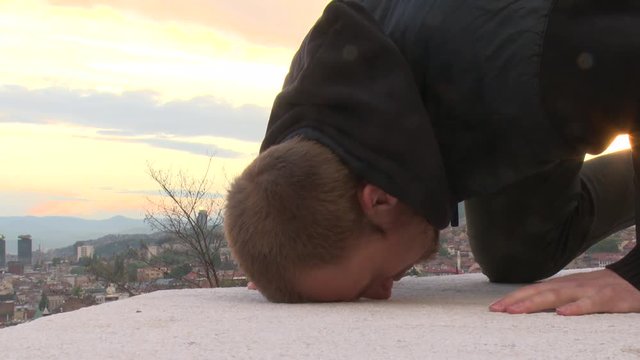 Young muslim man praying during sunset