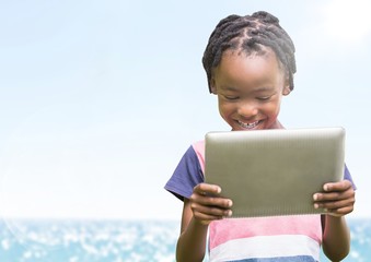 Obraz premium Boy with tablet against blurry water and flare