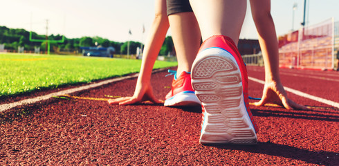 Female athlete on the starting line of a stadium track