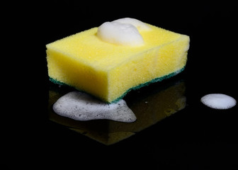 Kitchen cleaning sponge with foam on mirrored black background