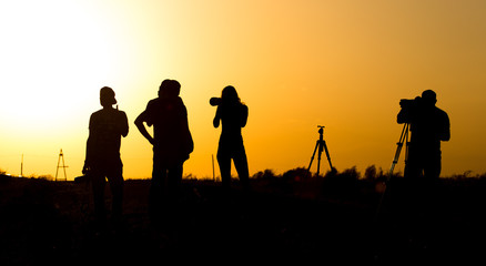 Fototapeta na wymiar Silhouettes of people with cameras at sunset