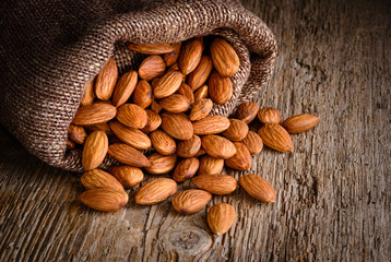 Almond. Nuts on textured wooden background. Organic food.