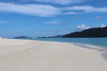 Fototapeta na wymiar White sand beach with boat blue sea background at Thailand