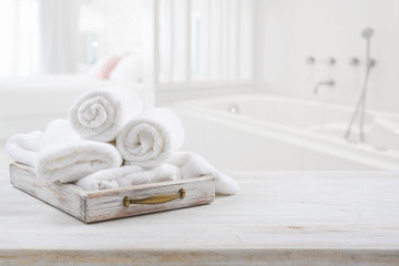 Vintage drawer with white towels over blurred bathroom and bedroom