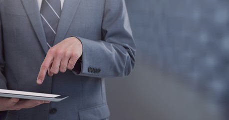 Businessman holding tablet with mid tone background