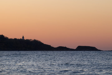 Silhouette lighthouse with light at sunset (Hendaye, France).