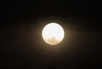The moon in the haze of the clouds at night